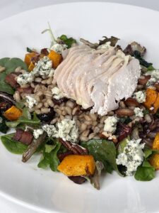 plate of salad, winter vegetables, sliced chicken on top
