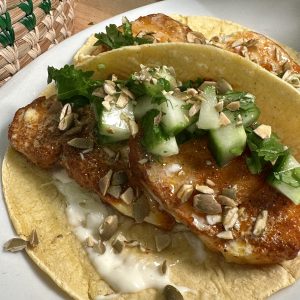 a plate of fish tacos with cucumber salsa