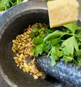 motar and pestle with fresh parsley and cheese