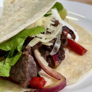 steak fajita in a floured tortilla with onion and peppers