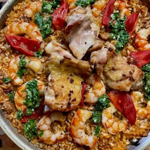 pan of paella with chicken, peppers and shrimp