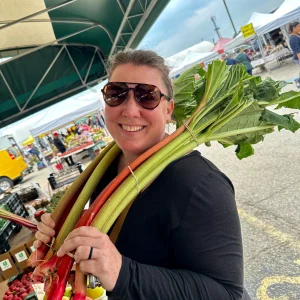 women hold rhubarb stalks