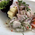 Plate of ceviche with red onion and corn