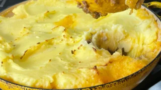 A spoonful of Shepherd's pie over a pan of shepherd's pie