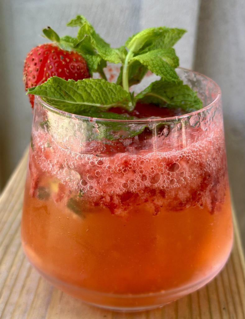 strawberry shrub in a rocks glass garnished with fresh mint