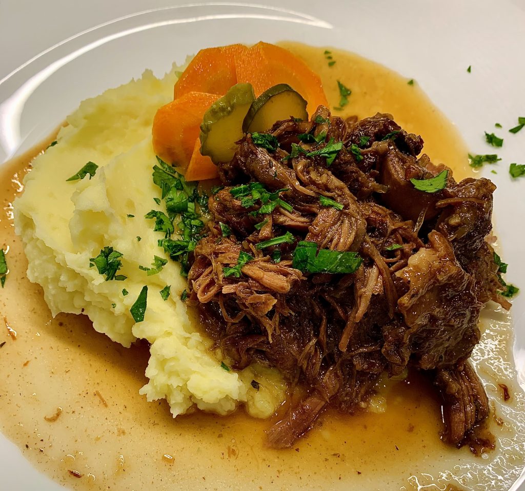 braised beef on a plate with pickled carrot