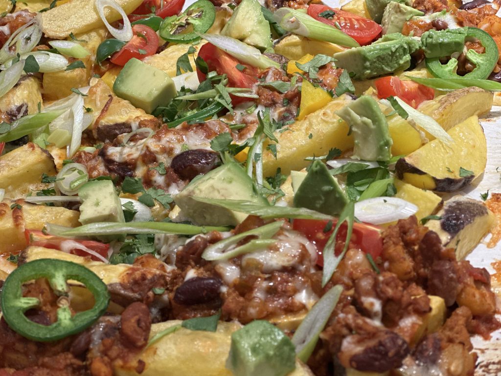 potato nachos focusing on toppings such as avocado, beef & beans