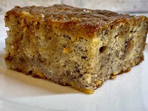banana bread on a plate with brown sugar glaze