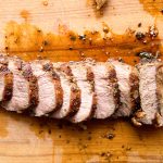 pork tenderloin, sliced on a cutting board