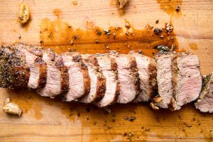 pork tenderloin, sliced on a cutting board
