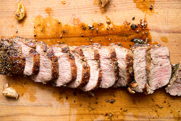 pork tenderloin, sliced on a cutting board