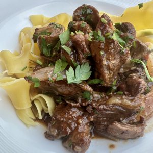 plate of beef bourguignon with noodles